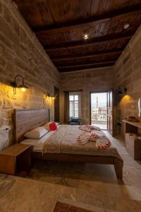 a bedroom with a large bed in a stone wall at feris cave hotel in Urgup