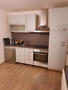 Una cocina con gabinetes blancos y electrodomésticos de acero inoxidable. en Sarajevo Viewpoint Old Town with Panoramic City Views, Free Parking and Balcony, en Sarajevo