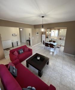 a living room with two red couches and a table at Margaret's House in Kefallonia +11 photos