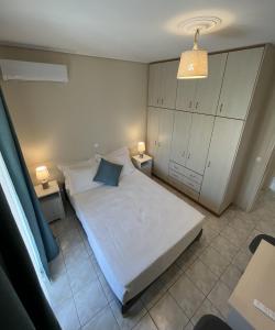 a bedroom with a white bed and two night stands at Margaret's House in Kefallonia