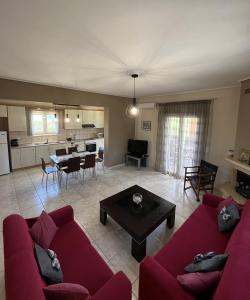 a living room with a red couch and a table at Margaret's House in Kefallonia