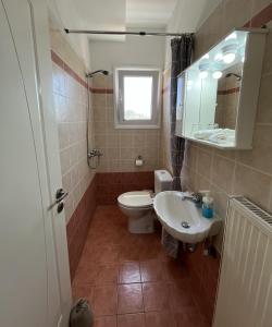 a bathroom with a toilet and a sink and a mirror at Margaret's House in Kefallonia