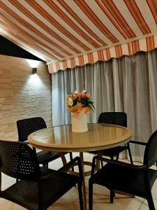 Una mesa con sillas y un jarrón de flores encima. en KlubNika, en Budva 2 fotos más