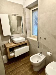 Un baño con un lavabo blanco y un inodoro. en La Villetta, en Torvaianica