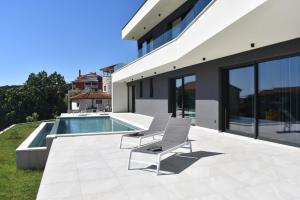 a patio with two chairs and a swimming pool at Villa M&M in Ližnjan