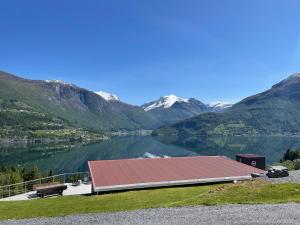 a building with a red roof next to a lake at Olden Tinyhouse - Modern Living in Olden