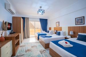 ein Hotelzimmer mit zwei Betten und einem Fernseher in der Unterkunft Hayat Pyramids View Hotel in Kairo