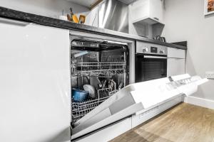 eine Küche mit einem offenen Geschirrspüler mit Geschirr darin in der Unterkunft Central Castle House in Norwich + 12 Fotos