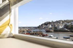 a view of a harbor from a window at La Petite Maison Apartments in Brixham