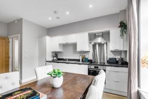 eine Küche mit einem Holztisch und weißen Schränken in der Unterkunft Central Castle House in Norwich