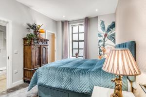 ein Schlafzimmer mit einem blauen Bett und einer Lampe in der Unterkunft Central Castle House in Norwich
