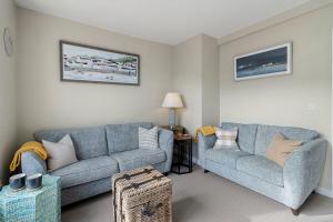 a living room with a couch and a chair at La Petite Maison Apartments in Brixham