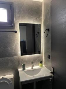 a bathroom with a sink and a mirror at RAMhouse II in Arta +6 photos