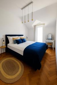 a bedroom with a large bed with a blue blanket at Mala Kuća in Hodilje +29 photos