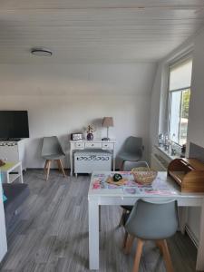 un soggiorno con tavolo e sedie bianchi di Ferienwohnung Altmann a Prerow