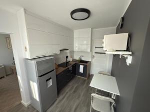 a small kitchen with a refrigerator and a table at NO 19 Apartment I Centrum I Parking I Klimatyzacja in Augustów