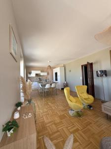 ein Wohnzimmer mit gelben Stühlen und einem Tisch in der Unterkunft La Plénitude face à la mer in Dunkerque