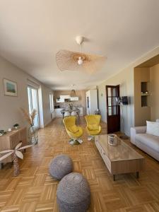 ein Wohnzimmer mit gelben Stühlen und einer Couch in der Unterkunft La Plénitude face à la mer in Dunkerque