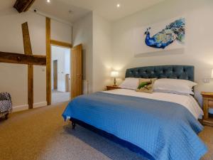 Redmarley DʼAbitotにある4 Bed in Ledbury 60200のベッドルーム1室(大型ベッド1台、青いヘッドボード付)