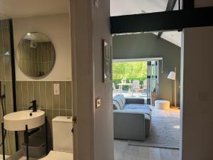 ein Schlafzimmer mit einem Bett, einem Waschbecken und einem Spiegel in der Unterkunft The Bothy - A secluded and romantic rural retreat in Llanddyfnan