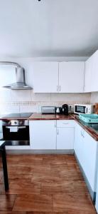 アロナにあるAmarilla Rockの白いキャビネットと木製の床を備えたキッチン