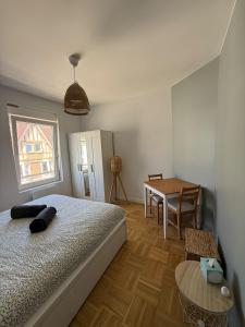 ein Schlafzimmer mit einem Bett und einem Tisch darin in der Unterkunft La Plénitude face à la mer in Dunkerque