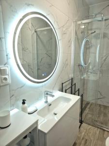 biała łazienka z umywalką i lustrem w obiekcie Brickstone Apartments Mabork w mieście Malbork +37 zdjęć