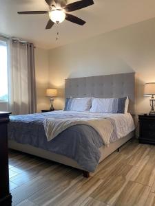 une chambre avec un grand lit avec un ventilateur de plafond dans l'établissement Desert Retreat -Quiet-Mountain views-hiking-golfing, à Tucson
