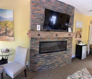 a living room with a fireplace with a flat screen tv at Glen Ellen Inn Secret Cottages in Glen Ellen