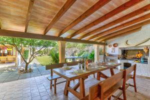 an outdoor dining room with a table and a fireplace at Villa Maite by Villa Plus in El Port
