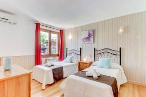 a hotel room with two beds and a window at Villa Maite by Villa Plus in El Port +18 photos