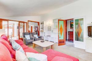a living room with a red couch and a table at Villa Maite by Villa Plus in El Port
