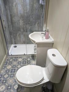 Un baño con inodoro, lavabo y ducha. en Rose Valley Ballycastle, en Ballycastle 13 fotos más