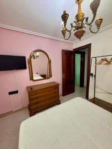a bedroom with a bed and a mirror and a dresser at La Mermellina, 22 in Arriondas