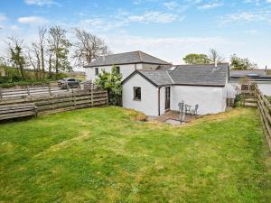 a white house with a fence and a yard at 1 Bed in Portreath OLDML in Camborne