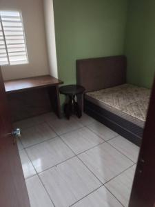 a room with two beds and a stool and a window at Morada ind in Araguari