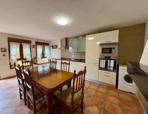 a kitchen with a wooden table and chairs in a room at La Mermellina, 22 in Arriondas