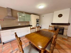 a kitchen with a wooden table with chairs and a sink at La Mermellina, 22 in Arriondas