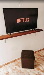a flat screen tv on a wall with a stool at Apartamento Mia Gran Tarajal in Gran Tarajal