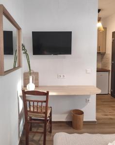 a room with a desk with a television on a wall at Kaia Studios Agnondas in Agnontas