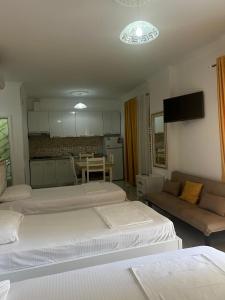 Vila Vitoria في Shëngjin: غرفة معيشة بها ثلاثة أسرة وأريكة