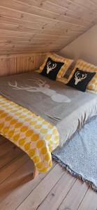 a bed in a room with a wooden floor at Mazurkowo domek Gaj-Grzmięca in Zbiczno