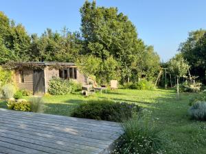 a garden with a wooden deck in the foreground at Maison en bois à la campagne proche vilaine in Férel