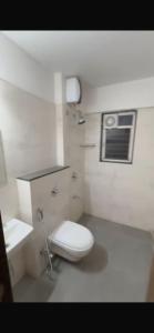 a white bathroom with a toilet and a sink at 3Bhk Bungalow Baner in Pune