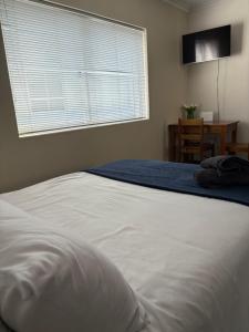 a white bed in a bedroom with a window at Brightways AirB&B in Summerstrand