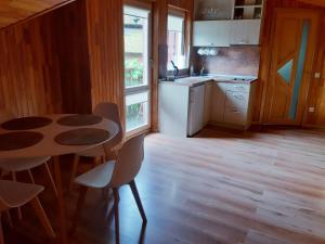a kitchen with a table and some chairs and a table at Pajūrio namai in Juodkrantė