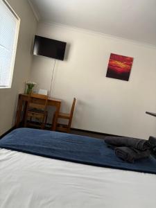 a bedroom with a bed and a desk and a television at Brightways AirB&B in Summerstrand