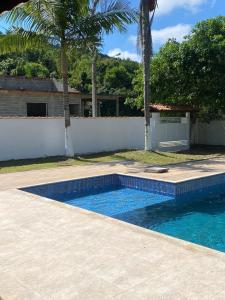 a swimming pool in front of a house at Seu Cantinho de Paz em Iguape in Iguape