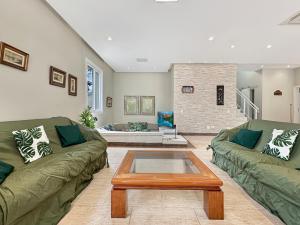 a living room with two couches and a coffee table at Suíte Piscina e Churrasqueira AC Acesso a Praia in Guarujá +15 photos