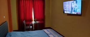 a bedroom with a bed and a desk and a television at Habitación privada, TV y WIFI cerca a Barranco - H2 in Lima